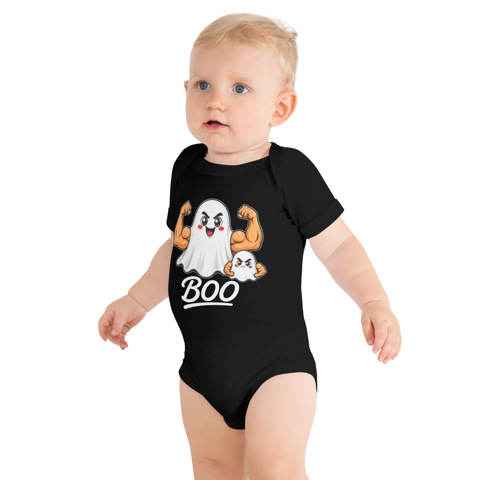 A baby with light hair and blue eyes stands against a plain background, wearing the Boo Ghost Baby One Piece - Halloween Edition from Straight Face Originals. This black onesie features a cartoon ghost flexing muscular arms with the word “BOO” printed below, making it the perfect spooky outfit for festive Halloween photos.