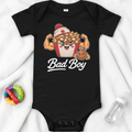 Dress your little rebel in the Bad Boy Baby One Piece - Canada Edition by Straight Face Originals—a high-quality black cotton bodysuit featuring a flexing cartoon poutine, a feisty little dog, and bold Bad Boy lettering. Perfect for budding streetwear stars, this adorable infant outfit is pictured with a colorful teether and baby bottle on a cozy white blanket.