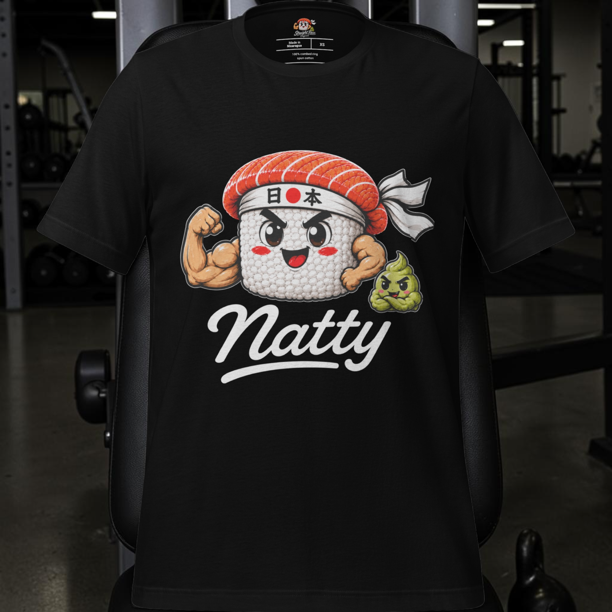 Introducing the Natty Tee – Japan Edition from Straight Face Originals. This premium black gym shirt features a cartoon sushi sporting muscular arms and a headband adorned with Japanese lettering, with the word “Natty” boldly printed below. A playful green wasabi dollop sits beside the sushi against a fun gym-inspired backdrop. Perfect for fitness enthusiasts and sushi lovers, this natty lifter tee is crafted on the ultra-comfortable Bella + Canvas 3001 for unbeatable style and comfort.
